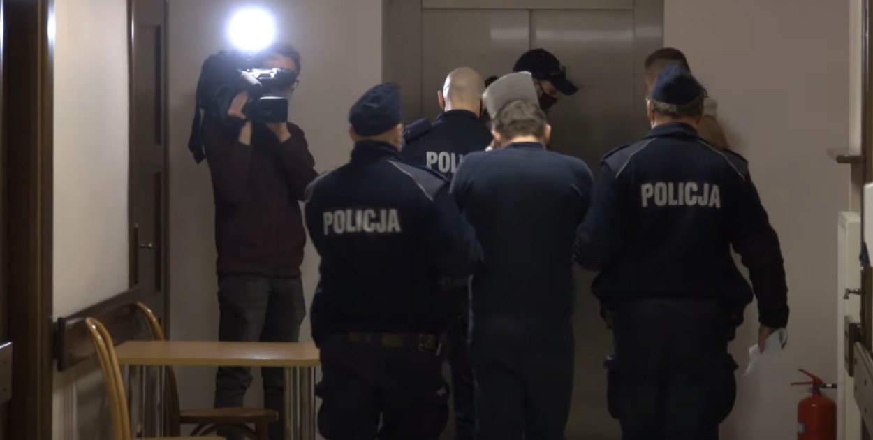 Doprowadzenie oskarżonego Michała G. Fot. Zrzut You Tube.